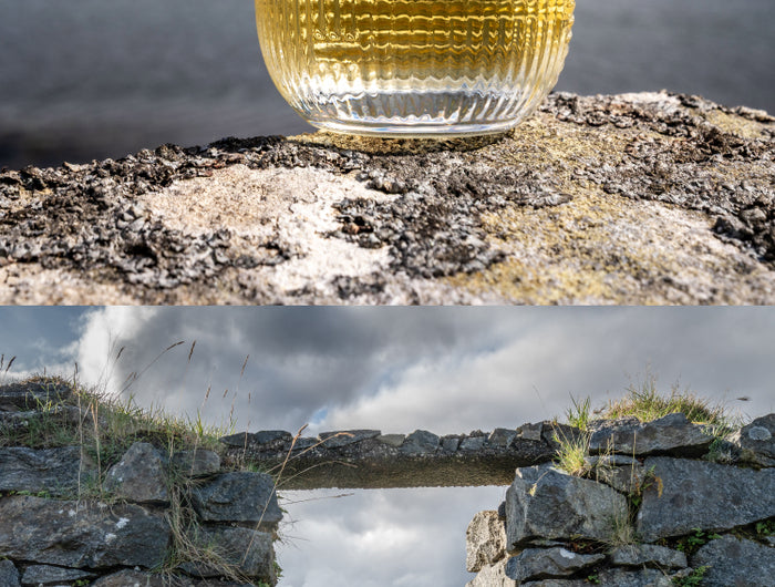 Glass of whisky on a stone ledge with a scenic background