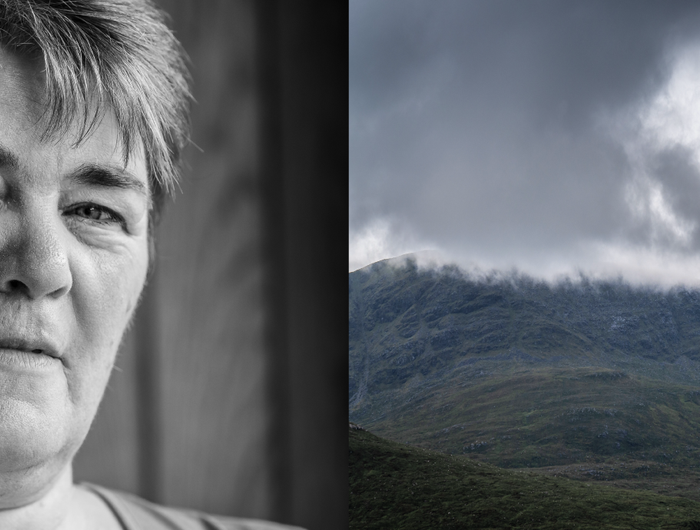 Portrait of a woman beside rugged hills under low cloud on Harris