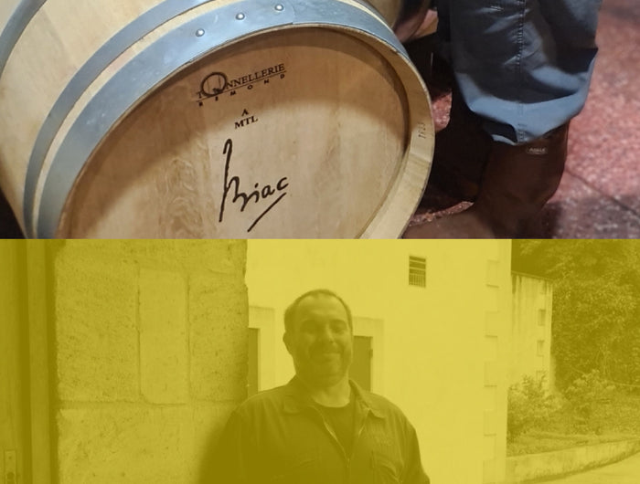 Close-up of a Château Biac wine cask alongside a person holding a sign indicating its delivery to Isle of Harris Distillery